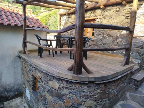 a wooden deck with a table and chairs on it at Casa da Avó Celta in Lousã