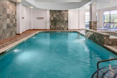 a pool in a hotel room with blue water at Courtyard Pittsburgh Greensburg in Greensburg