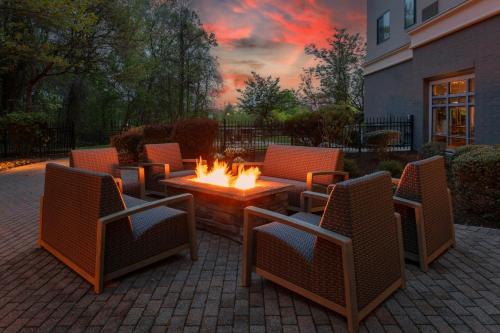 a patio with a table and chairs with a fire pit at Courtyard Pittsburgh Greensburg in Greensburg
