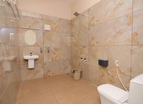 a bathroom with a toilet and a sink at Nandanam Villa in Kaniyāmbetta