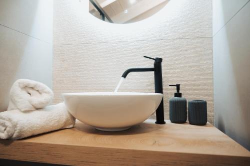 a bathroom sink with a faucet and towels on a wooden counter at Eveline Suite - seaview & short walk to the beach in Nikiana