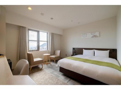 a hotel room with a large bed and a chair at HOTEL enoe Hakodate - Vacation STAY 78527v in Hakodate