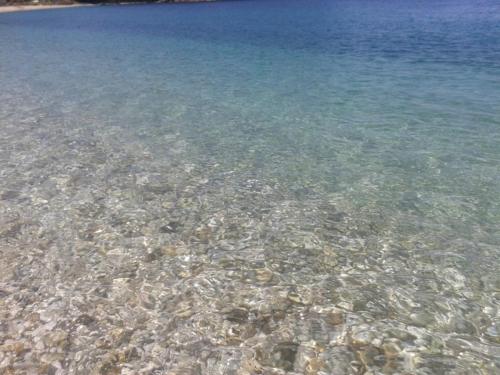 a large body of crystal clear water with rocks at Magic Ionian Apartments & Rooms in Himare