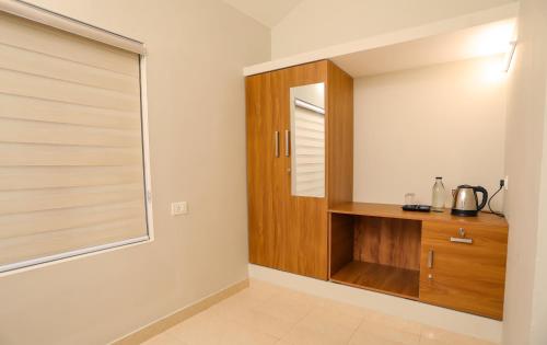 a room with a wooden cabinet and a window at Nandanam Villa in Kaniyāmbetta
