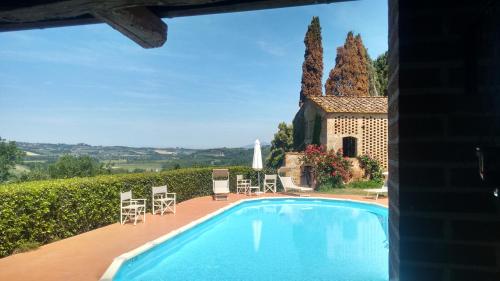 a swimming pool in front of a house at Agriturismo I Moricci in Peccioli