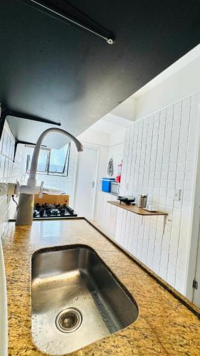 a kitchen with a sink in the middle of it at Descanso Ed. Timoneiro próximo orla in Maceió