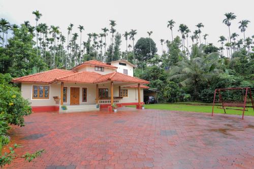 a house with a basketball hoop in front of it at Nandanam Villa in Kaniyāmbetta
