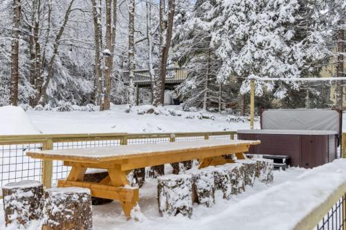 a picnic table covered in snow in a yard at Maple Pine w Hot Tub Pool Table 3min to Mount Snow in Dover