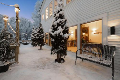 a porch with a snow covered tree and benches at Maple Pine w Hot Tub Pool Table 3min to Mount Snow in Dover