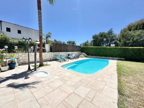 - une piscine avec 2 chaises et un palmier dans l'établissement Magnifique studio, piscine, parking Nice, à Nice