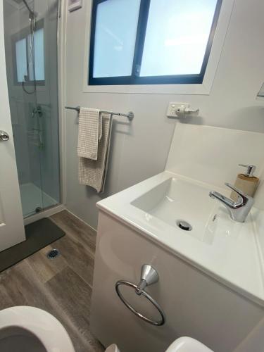 a bathroom with a sink and a toilet and a window at Mountain Escape in Wentworth Falls