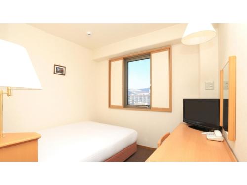 a bedroom with a bed and a desk with a television at Smile Hotel Nara - Vacation STAY 73673v in Nara