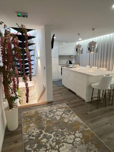 a kitchen with white cabinets and a table and chairs at Sequeira Arantes Casa 2 in Terras de Bouro