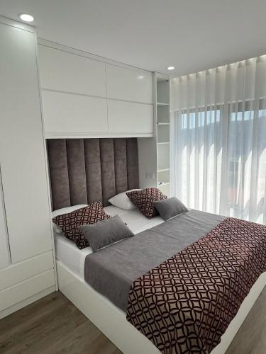a bedroom with a large bed with a large window at Sequeira Arantes Casa 2 in Terras de Bouro