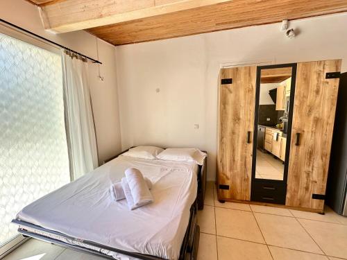une petite chambre avec un lit et un miroir dans l'établissement Magnifique studio, piscine, parking Nice, à Nice