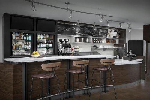 a kitchen with a bar with bar stools at Courtyard Philadelphia Great Valley/Malvern in Malvern