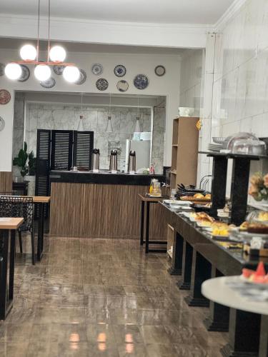 a large kitchen with a counter with food on it at Hotel Coqueiros in Valparaíso de Goiás