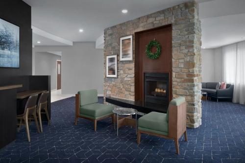 a lobby with a fireplace and a table and chairs at Courtyard Philadelphia Great Valley/Malvern in Malvern