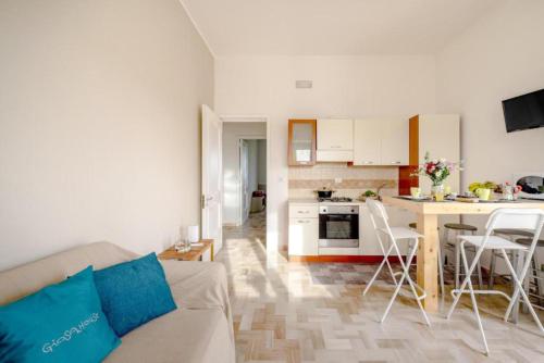 a living room with a couch and a kitchen at GIOSAHOUSE in Uggiano la Chiesa