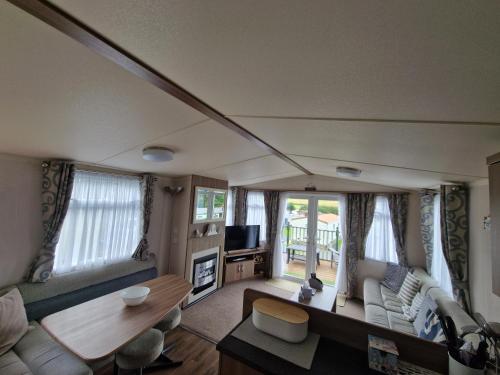 a living room with a couch and a table at Green Heaven at Clarach Bay Spacious 3 BedPet Friendly Luxury Steps from the Sea in Aberystwyth