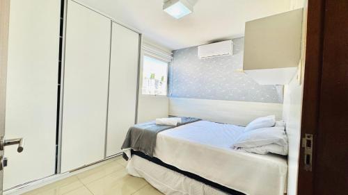 a small room with a bed and a window at Descanso cond edifício tropical B in Maceió