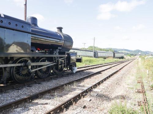 a black train is sitting on the tracks at The Old Lighthouse Cottage in Watchet