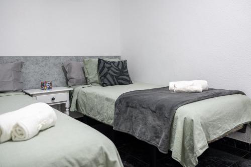 a room with two beds and a table with a bedskirts at Juanvi's Corner in Costa de Adeje