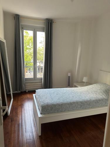 une chambre blanche avec un lit et une fenêtre dans l'établissement Appartement Paris 16, à Paris