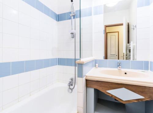 a bathroom with a sink and a tub and a mirror at L'instant Deauville - F2 avec Piscine - Résidence du Golf in Deauville
