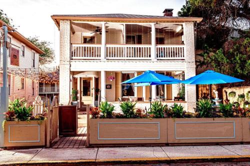 a house with two blue umbrellas in front of it at Inn on Charlotte Boutique Hotel in St. Augustine