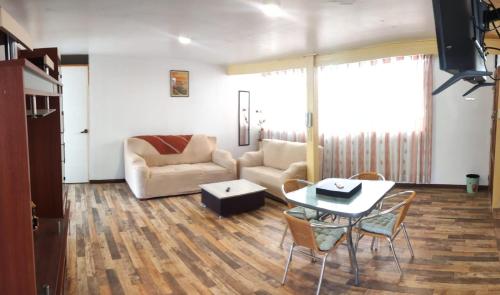a living room with a couch and a table and chairs at La Casa Hospedaje Kory Ayllu in Cusco