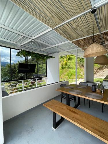a dining room with two tables and a television at Colina Shalom nature & comfort in Nocaima