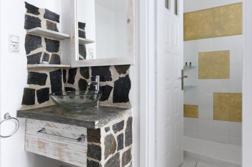 a bathroom with a stone sink and a shower at Porto Naoussa in Naousa