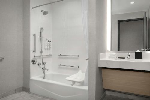 a bathroom with a shower and a tub and a sink at TownePlace Suites by Marriott Bozeman West in Bozeman