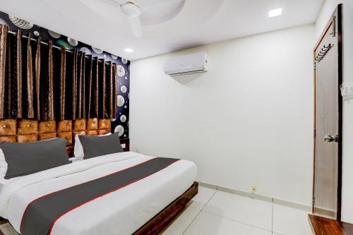 a bedroom with a large bed and a window at Collection O Lotus Gold in Vadodara