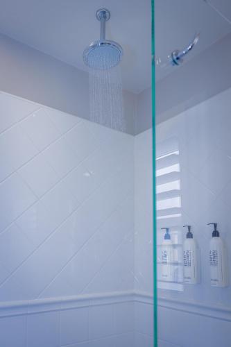 a shower with a glass door in a bathroom at Marina Beach Motel in Santa Barbara