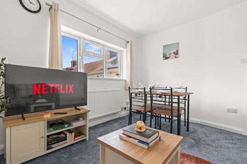 a living room with a tv and a dining table at Flat with free parking in Oxford in Oxford