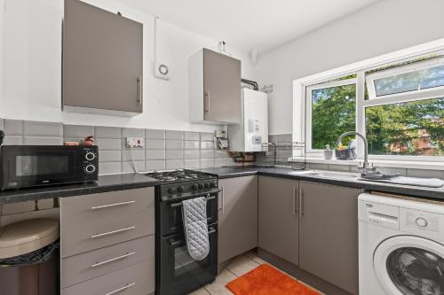 a kitchen with a stove and a microwave at Flat with free parking in Oxford in Oxford