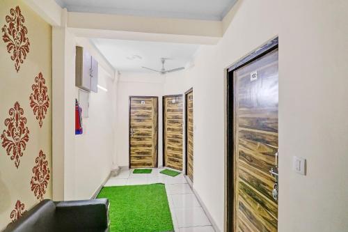 a hallway with a green floor and refrigerators at Super Hotel O Shankar Hotel Ghaziabad Railway Station in Ghaziabad