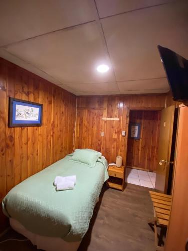 a bedroom with a bed with a towel on it at Hotel Elizabeth in Coñaripe