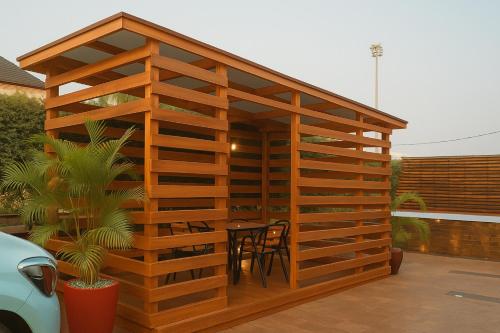 a wooden gazebo with a table and chairs at SEATWORK APARTMENT Enugu in Enugu Airport