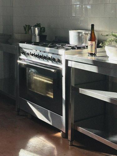 a kitchen with a stove and a bottle of wine at Agriturismo Casa Cometa in Principina a Mare