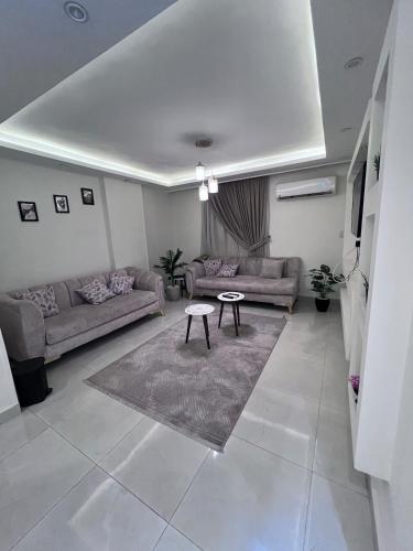a living room with two couches and a table at Modern apartment in Sheraton in Kafr Abû Sîr