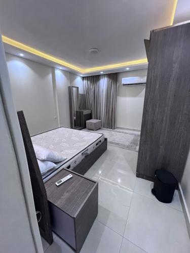 a bedroom with a bed and a table in it at Modern apartment in Sheraton in Kafr Abû Sîr