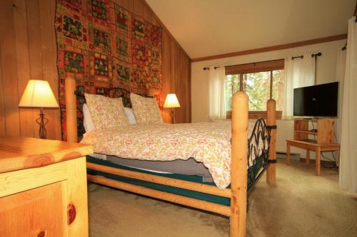 a bedroom with a bed and a television in it at Mountainback #117, Loft in Mammoth Lakes