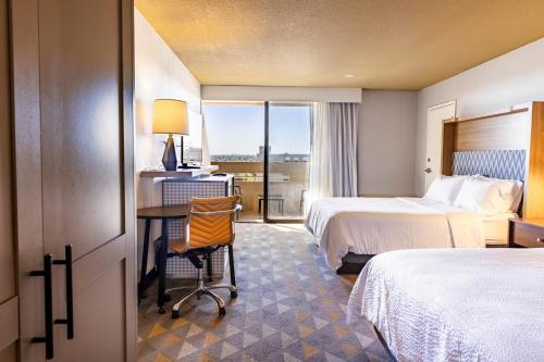 丹佛Holiday Inn Denver East by IHG的有两张床和一张书桌的酒店房间