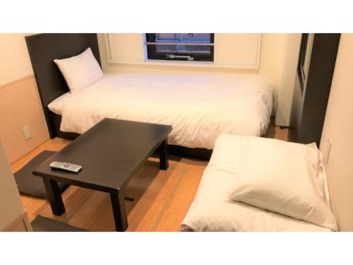 a room with two beds and a table and a couch at Smile Hotel Kawaguchi - Vacation STAY 76828v in Kawaguchi