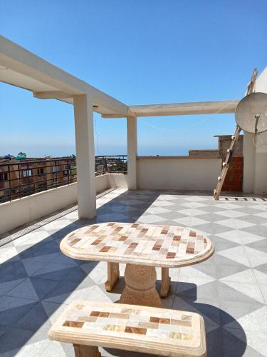 a table on a roof with a view of the ocean at Cléopâtre épouse de Juba ll in Tefeschoun