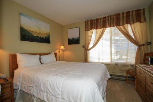a bedroom with a white bed and a window at Discovery 4 137 in Mammoth Lakes