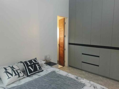 a bedroom with a bed with two pillows on it at The CozyNest Camiguin Homestay in Mambajao